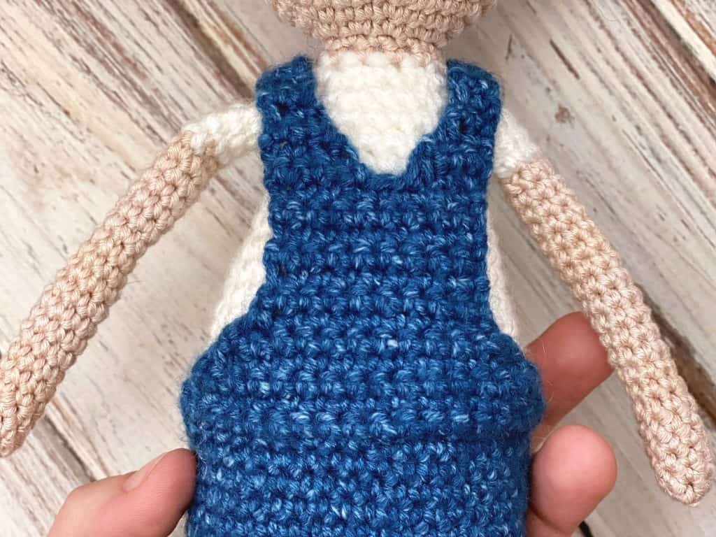 close up of doll overalls back