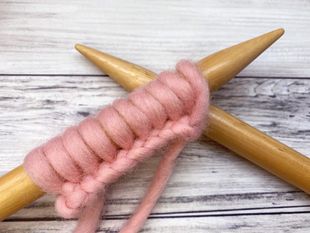 knitting needles with several stitches cast on with the knitted cast on method