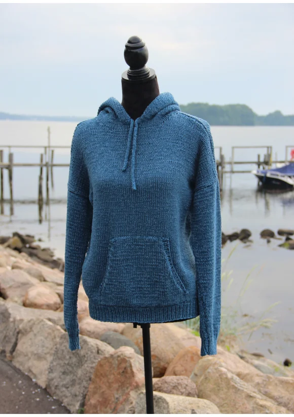 blue knit hoodie in front of lake scene