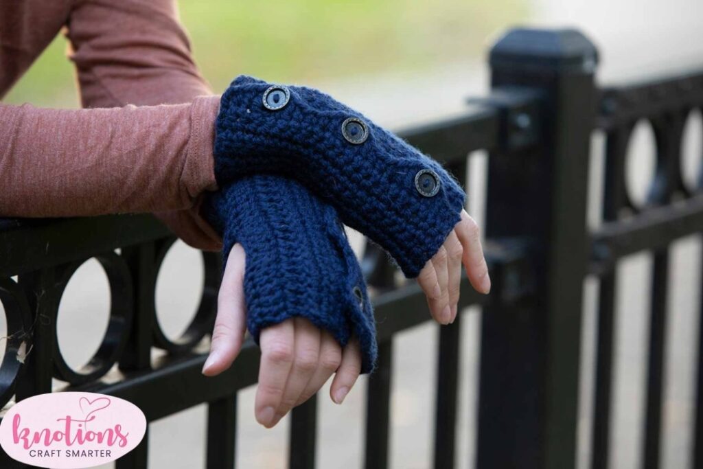 pair of hands wearing blue crochet mitts