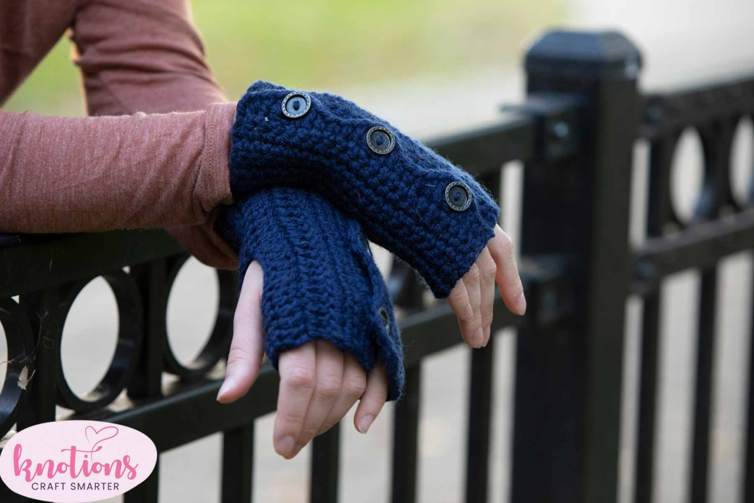 woman wearing a matching tan and blue crochet set of hat and fingerless gloves