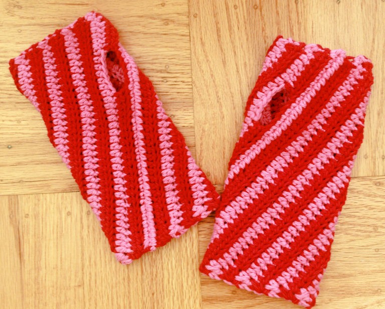 candy cane striped fingerless gloves on wooden background