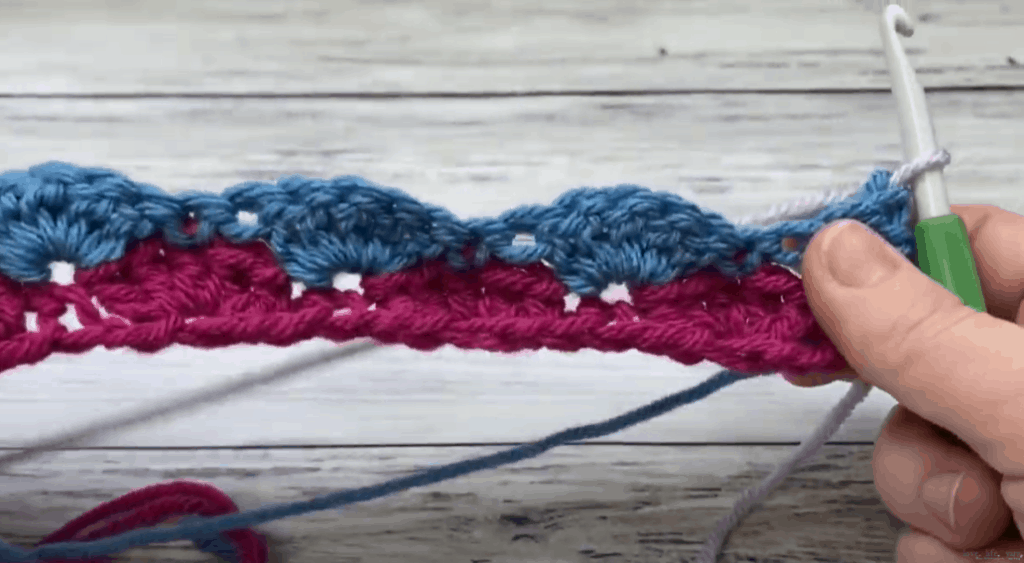 a hand holding 5 double crochet